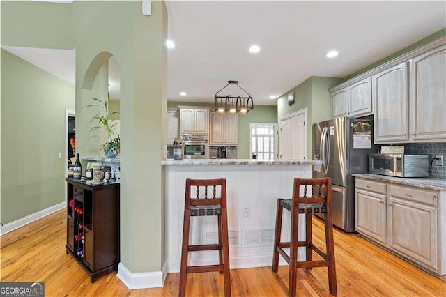 3130 Kates Way NW, Kennesaw, GA 30152 - kitchen featuring appliances with stainless steel finishes, backsplash, baseboards, light wood-style flooring, and recessed lighting
