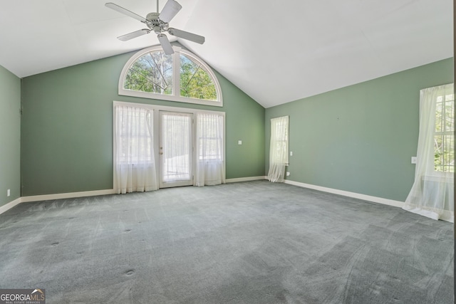 unfurnished living room with ceiling fan, high vaulted ceiling, carpet, and baseboards
