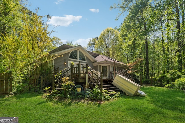 back of house with a deck, stairway, and a lawn