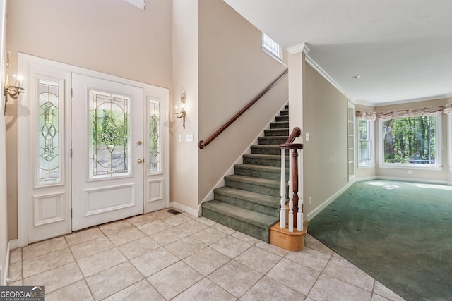 carpeted foyer with tile patterned floors, stairway, and baseboards