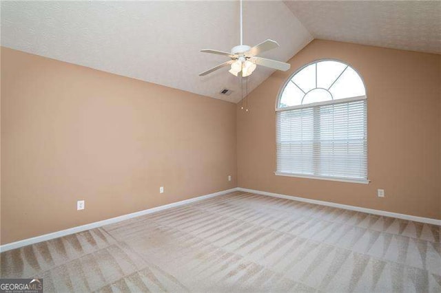 unfurnished room featuring lofted ceiling, a textured ceiling, light colored carpet, and ceiling fan