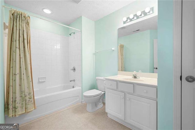 full bathroom featuring vanity, toilet, shower / bath combo with shower curtain, and a textured ceiling