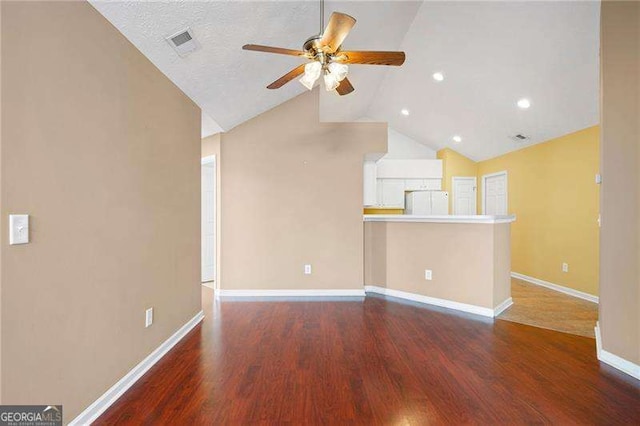 unfurnished living room featuring lofted ceiling, dark hardwood / wood-style floors, and ceiling fan