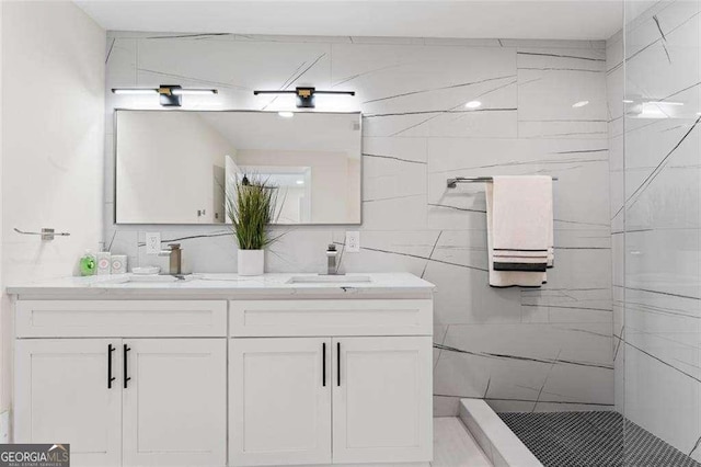 bathroom with tiled shower and vanity