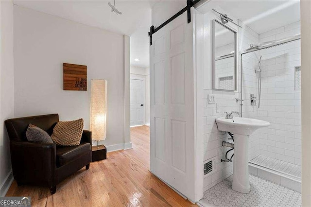 bathroom featuring sink, hardwood / wood-style floors, and a tile shower