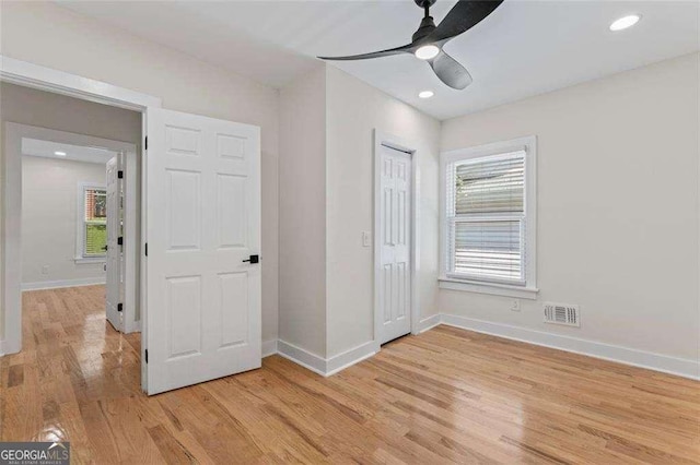 unfurnished bedroom with ceiling fan, a closet, and light hardwood / wood-style flooring