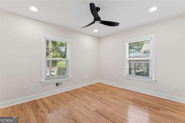 spare room featuring plenty of natural light, ceiling fan, and light hardwood / wood-style flooring