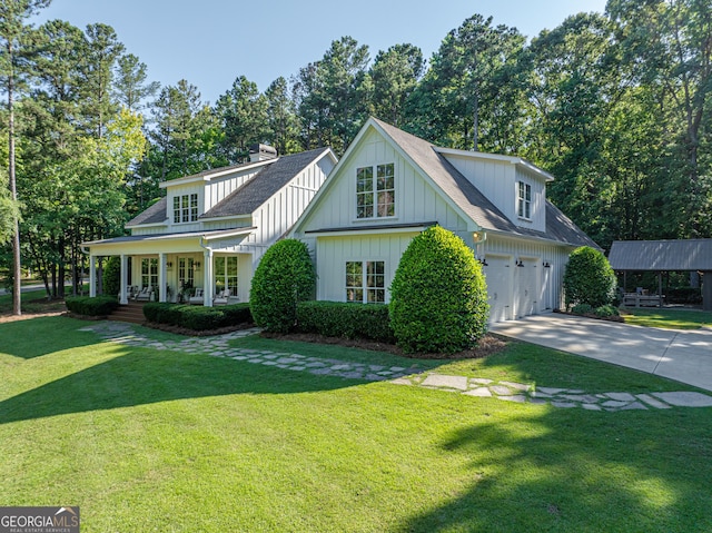 view of front of house with a garage, covered porch, and a front lawn