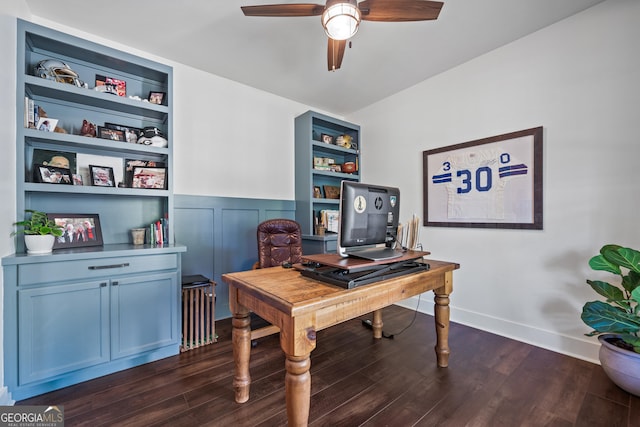 office area with built in shelves, ceiling fan, and dark hardwood / wood-style flooring