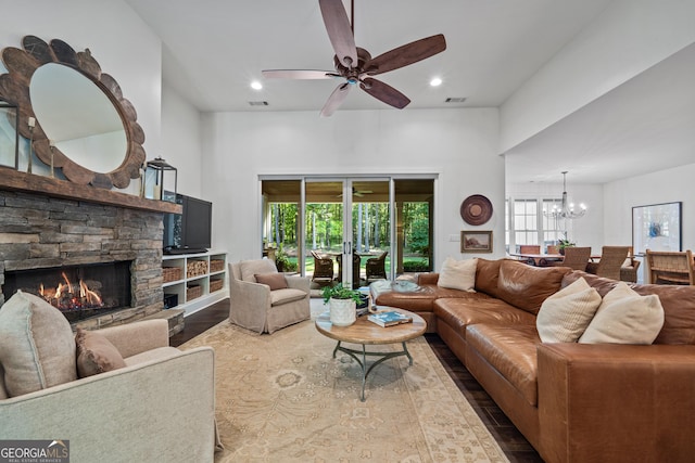 living room with a healthy amount of sunlight, a fireplace, ceiling fan with notable chandelier, and wood-type flooring