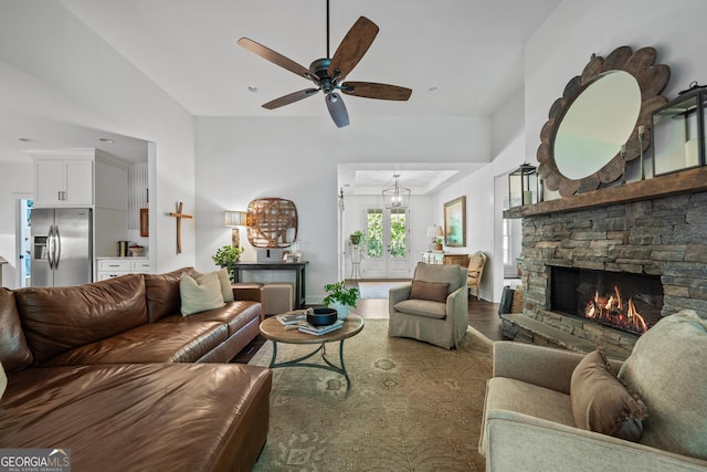 living room with a stone fireplace and ceiling fan