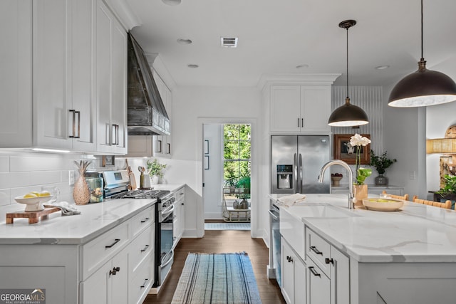 kitchen featuring light stone counters, appliances with stainless steel finishes, custom exhaust hood, and hanging light fixtures