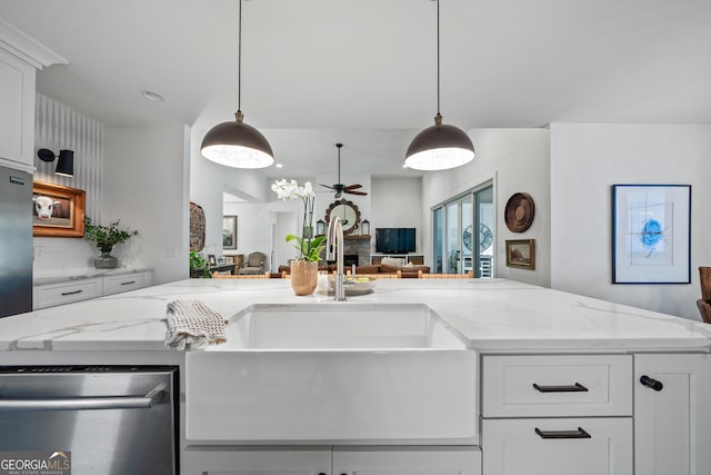 kitchen featuring white cabinetry, decorative light fixtures, and light stone counters