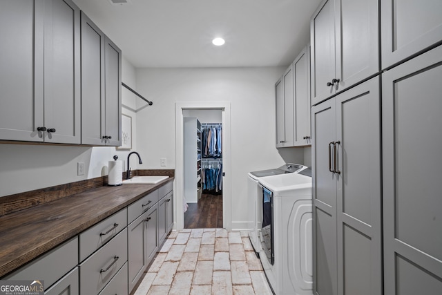 laundry room featuring cabinets, washing machine and dryer, and sink