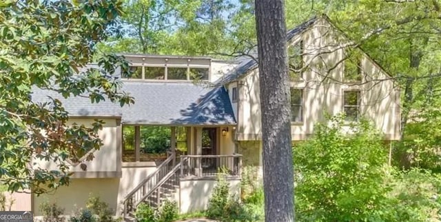 view of front of home with stairway and stucco siding