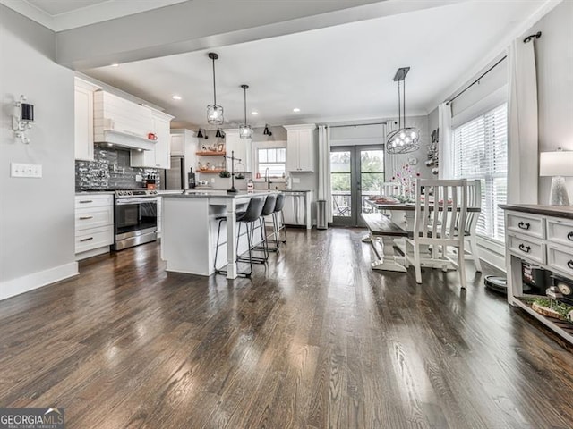 kitchen with a breakfast bar area, dark wood finished floors, french doors, appliances with stainless steel finishes, and backsplash