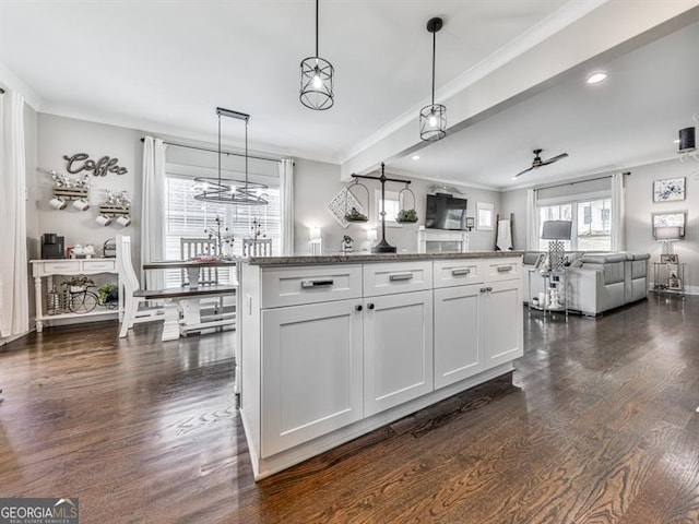 kitchen with crown molding, decorative light fixtures, open floor plan, dark wood-style floors, and white cabinets