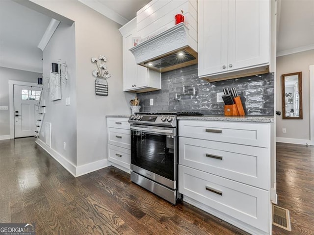 kitchen with dark wood finished floors, ornamental molding, light stone counters, decorative backsplash, and stainless steel range