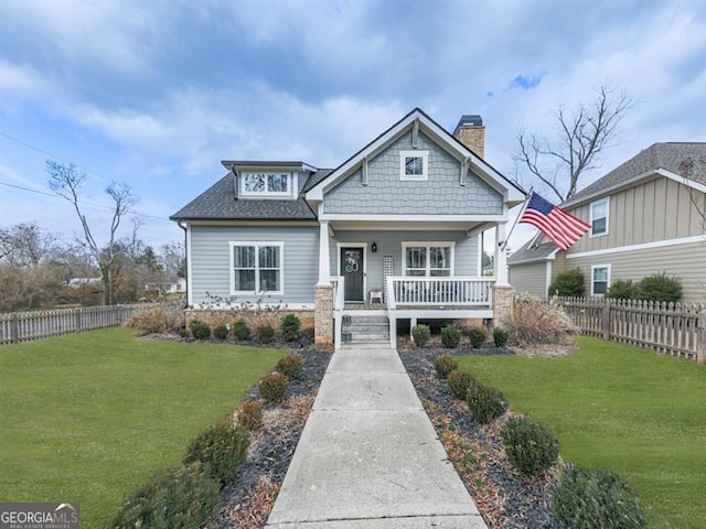 craftsman house featuring covered porch and a front lawn