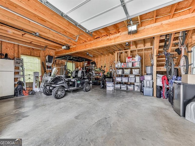 garage featuring a garage door opener and freestanding refrigerator