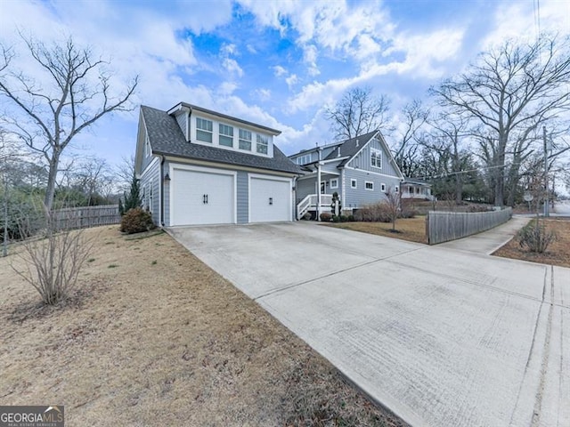 view of front of home featuring concrete driveway, an attached garage, fence, and a shingled roof