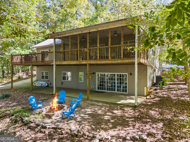 rear view of property featuring a fire pit, ceiling fan, central AC, a patio area, and a sunroom