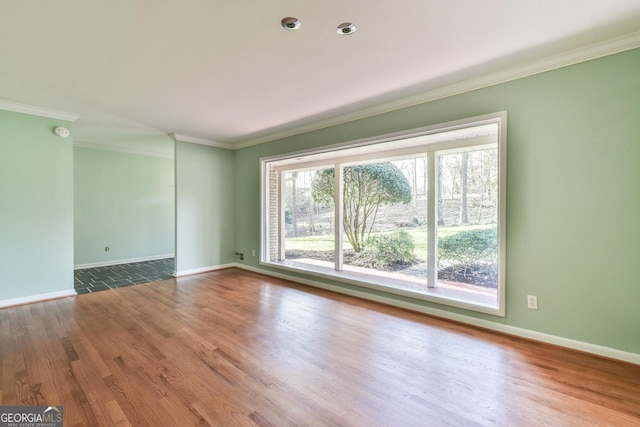 empty room with hardwood / wood-style flooring and crown molding