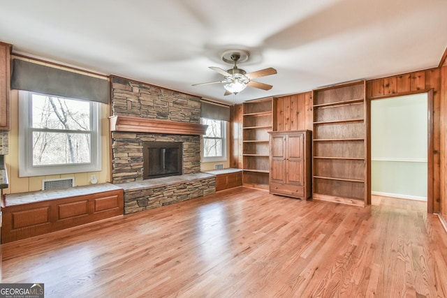 unfurnished living room with light hardwood / wood-style floors, ceiling fan, and a fireplace