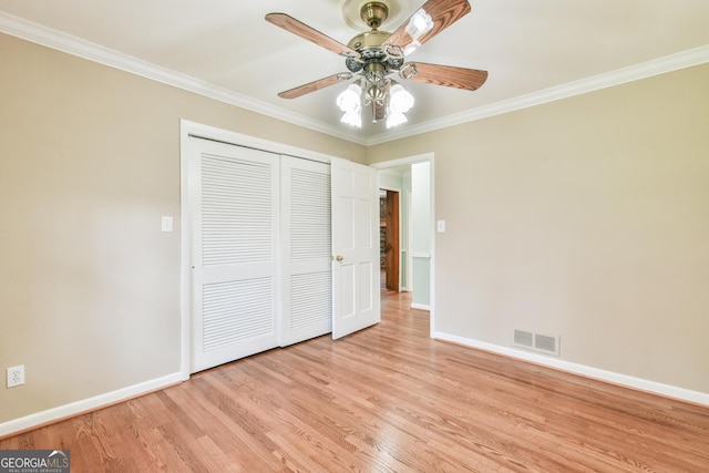 unfurnished bedroom featuring light hardwood / wood-style floors, a closet, ceiling fan, and ornamental molding