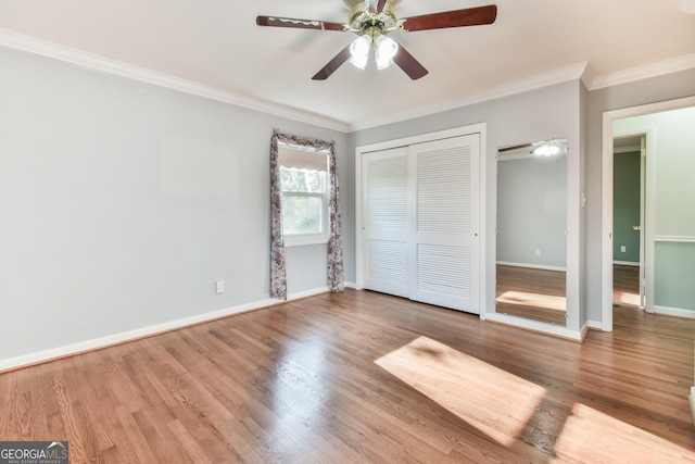 unfurnished bedroom with hardwood / wood-style floors, a closet, ceiling fan, and ornamental molding