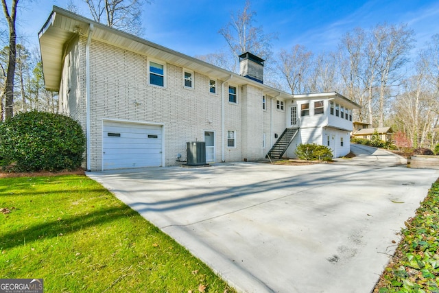 view of home's exterior with central air condition unit and a garage