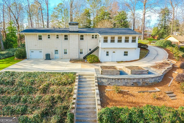 back of property featuring a garage and central AC