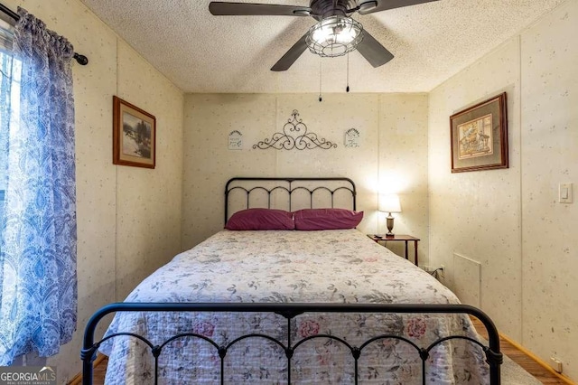 bedroom featuring ceiling fan and a textured ceiling