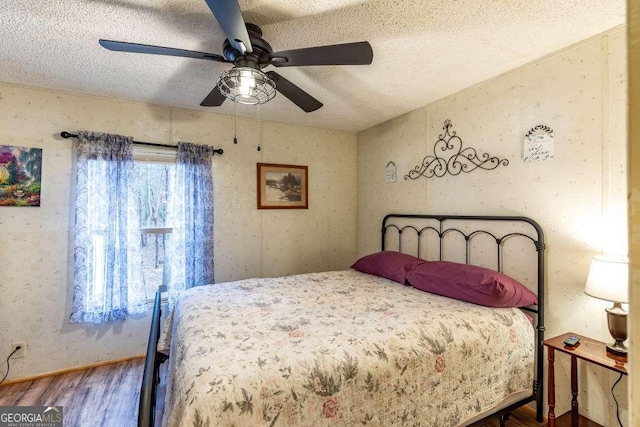 bedroom with hardwood / wood-style floors, a textured ceiling, and ceiling fan