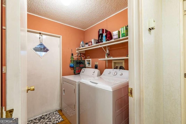 laundry room with washer and dryer and a textured ceiling