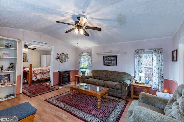 living room with hardwood / wood-style flooring, lofted ceiling, a healthy amount of sunlight, and a textured ceiling