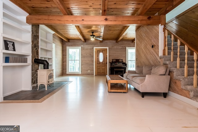 living room featuring wood ceiling, wood walls, plenty of natural light, and a wood stove