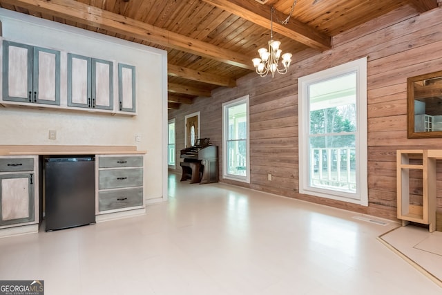 kitchen featuring wood ceiling, light countertops, fridge, beam ceiling, and pendant lighting