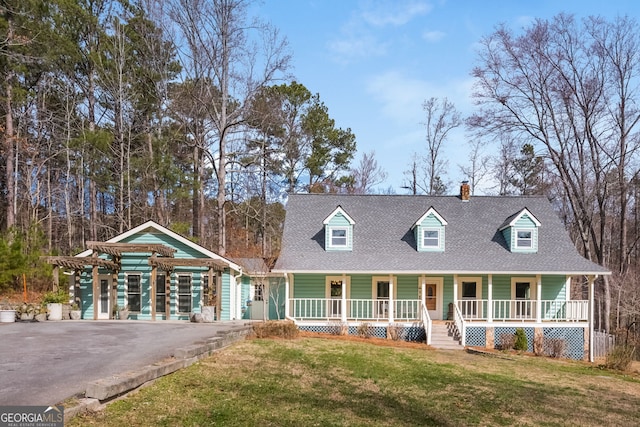 view of front of property featuring a shingled roof, a front yard, covered porch, and driveway