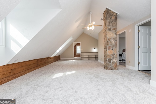 bonus room with light carpet, lofted ceiling, a ceiling fan, and baseboards