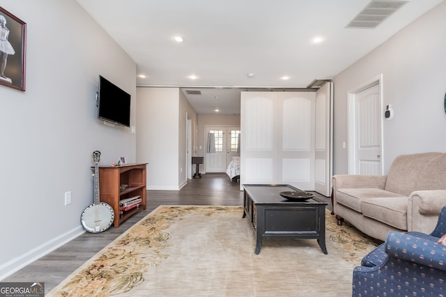 living room featuring baseboards, visible vents, dark wood-type flooring, and recessed lighting