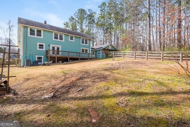 back of property with a yard, a chimney, fence, and central air condition unit