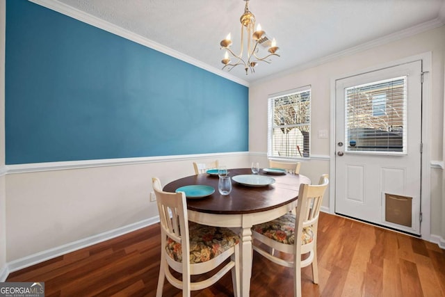 dining space featuring hardwood / wood-style flooring, ornamental molding, and a chandelier