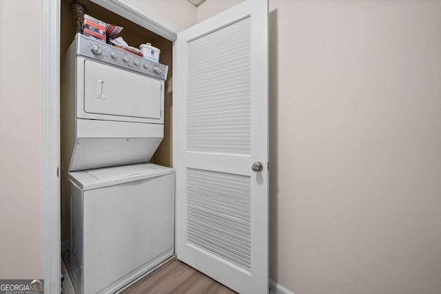 washroom with light wood-type flooring and stacked washing maching and dryer