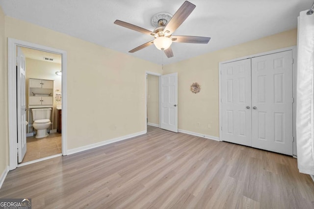 unfurnished bedroom featuring a closet, connected bathroom, ceiling fan, and light hardwood / wood-style flooring