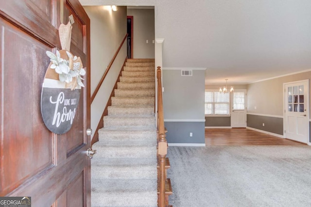 stairs with crown molding, a chandelier, and carpet