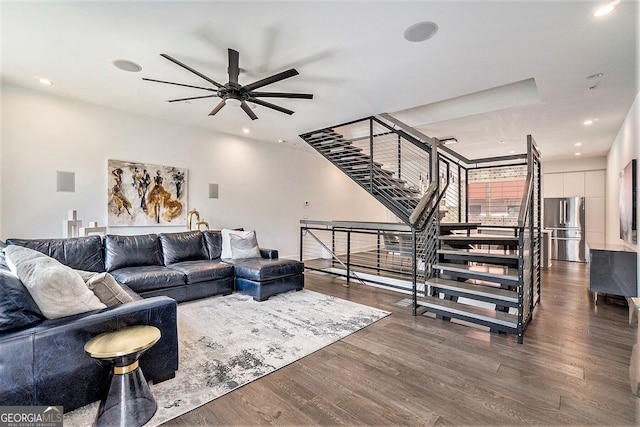 living room featuring dark wood-type flooring and ceiling fan