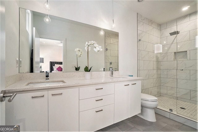 bathroom featuring a shower with door, vanity, tile patterned flooring, and toilet