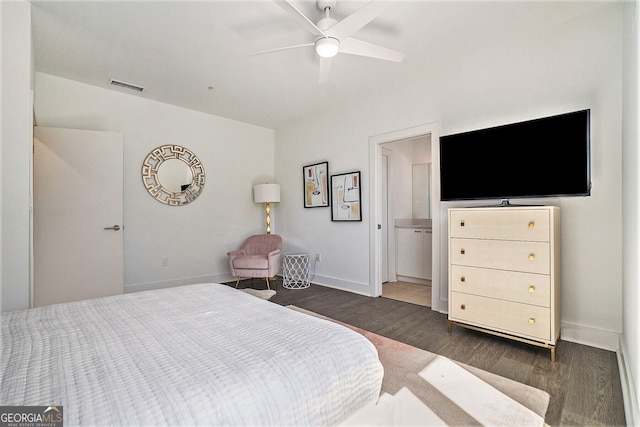 bedroom featuring dark hardwood / wood-style flooring, ensuite bath, and ceiling fan