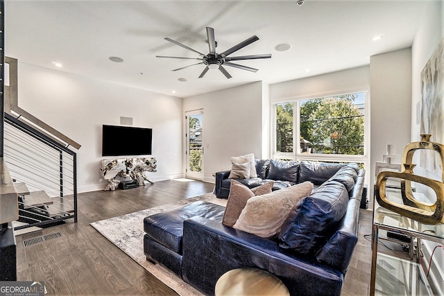 living room featuring ceiling fan and dark hardwood / wood-style floors